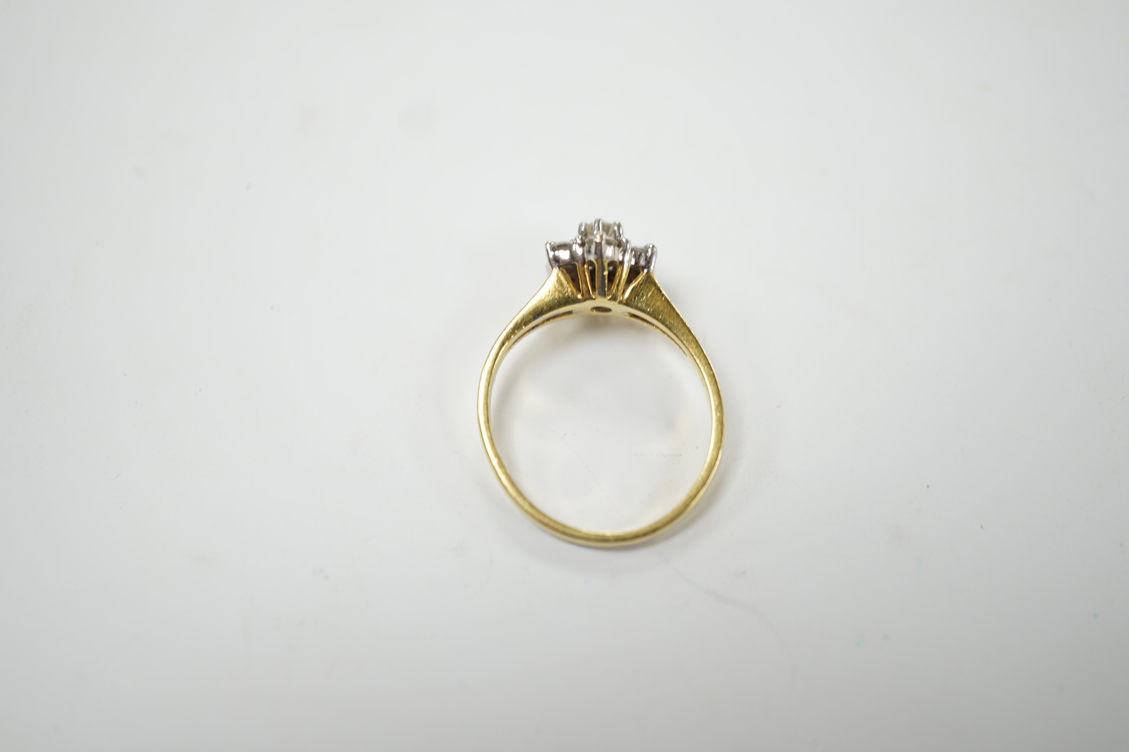 A modern 18ct gold and seven stone diamond set flower head cluster ring, size M, gross weight 3.2 grams. Fair condition.